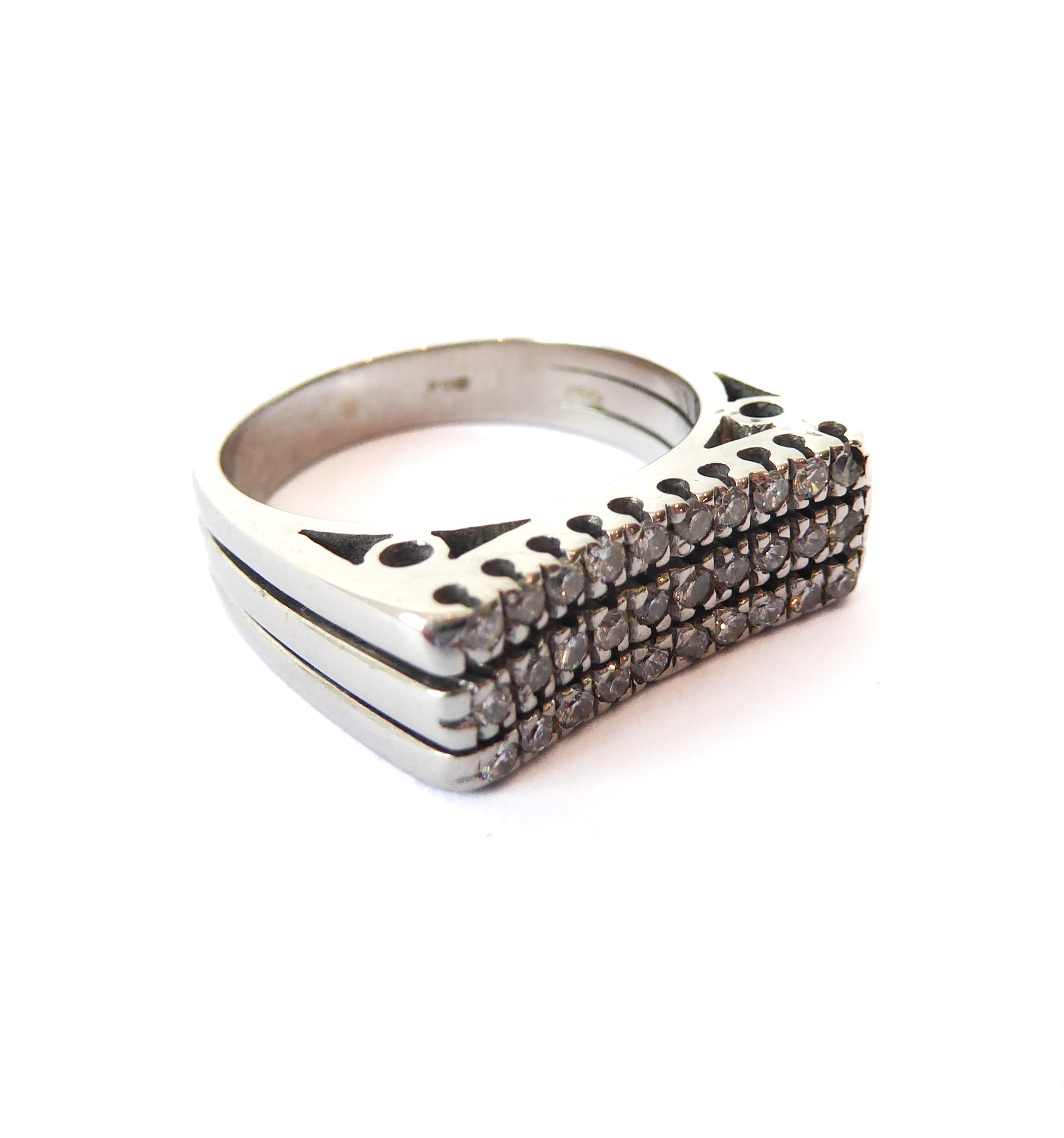 An 18ct white gold and diamond three row ring - marked '750', the slightly concave top set with