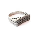 An 18ct white gold and diamond three row ring - marked '750', the slightly concave top set with