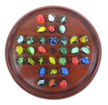 A 19th century mahogany solitaire game with marbles.