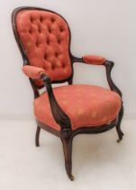 A mid-19th century rosewood and buttonback upholstered open armchair of slender proportions and in