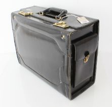 A black leather flight case by Spartan - with gold toned hardware, combination locks, two side