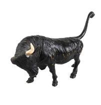 An early/mid 20th century black painted, Spanish-style bronze bull: tail raised and with head