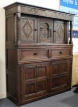A late 17th century oak court cupboard: the outset cornice above a frieze centrally carved with