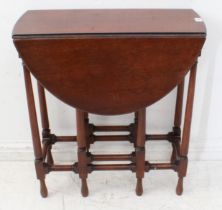 An Edwardian walnut spider table in late 18th century style: moulded oval top above slender turned