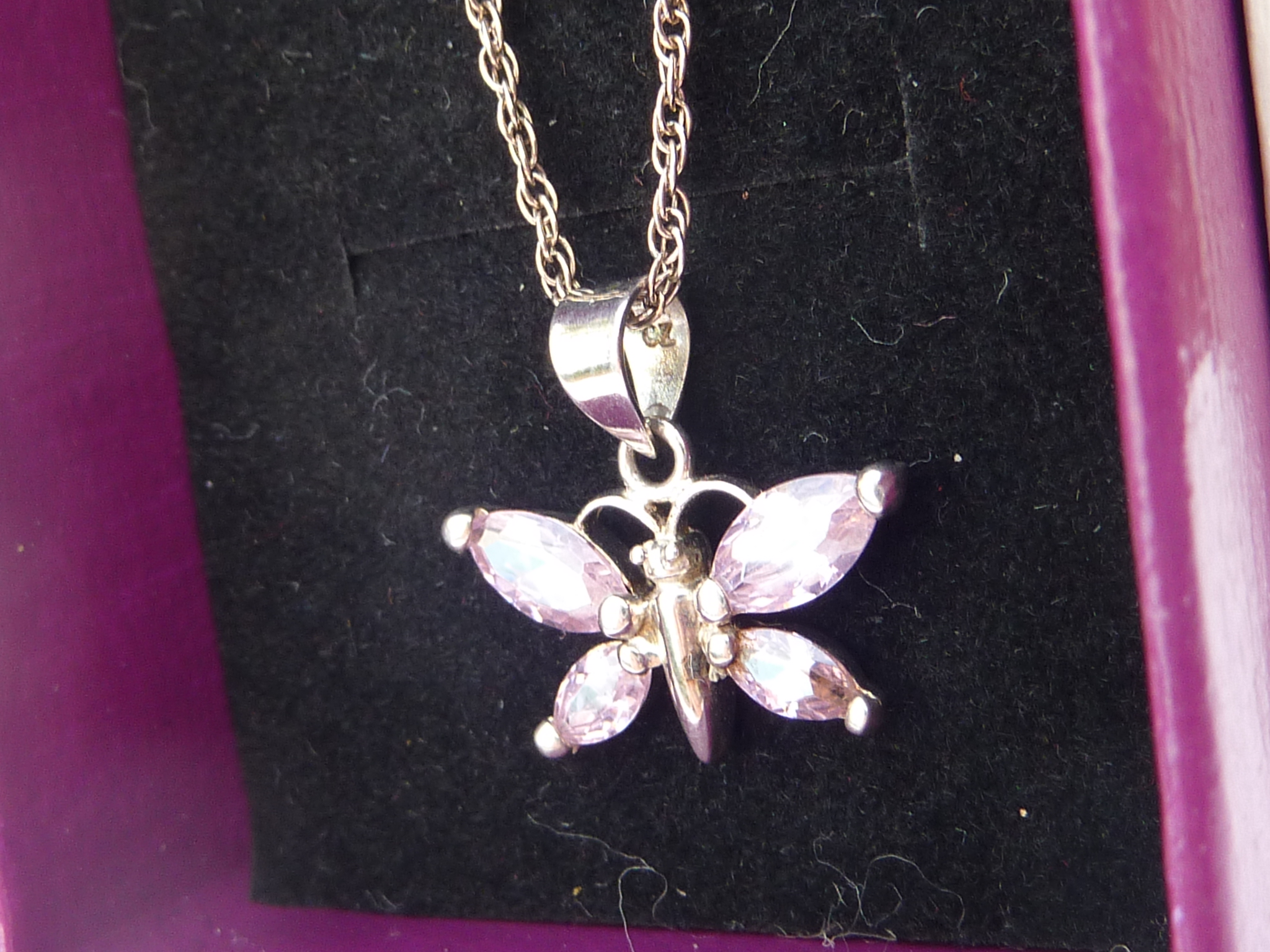 A boxed silver pendant modelled as a butterfly with hand-cut pink stones upon a silver chain. - Image 2 of 2