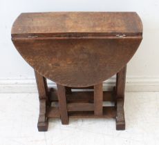 An early 20th century oval-topped oak drop-leaf table - raised on square supports chamfered in