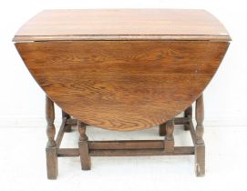 A mid-20th century oval-topped oak dropleaf gateleg table on baluster turned supports (LWH 135.5 (