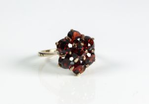 A 9ct yellow gold and garnet cluster ring - stamped '9CT', with a cluster of seven round cut