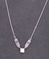 A silver chain mounted with a square hand-cut pink stone supported by two pierced Arts & Crafts