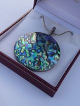 A large silver mounted mother of pearl pendant upon a silver chain (5 cm diameter) (boxed).
