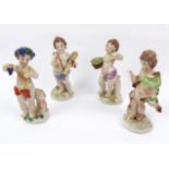 Four Naples porcelain putti figures.