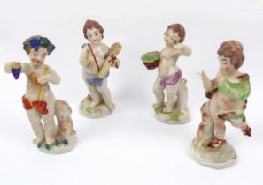 Four Naples porcelain putti figures.