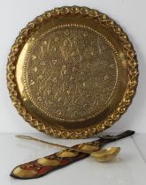 A large hand embossed circular brass tray together with a 19th century martingale and large brass