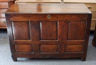 An early 18th century joined oak six-panel coffer - the moulded, three-plank top (hinges missing),