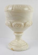 A modern alabaster urn: carved with leaves to the rim and stylised rose heads below, raised on