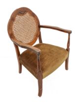 A single Art Deco period walnut and upholstered open armchair: shaped rattan caned back above