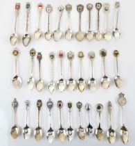 A small collection of silver-plated commemorative teaspoons: most with topographical enamel