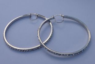 A pair of silver hoop earrings set with small hand-cut white stones (5 cm diameter).