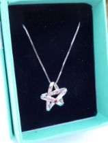 A silver star-shaped pendant set with a small hand-cut pink stone, upon a silver chain (boxed).