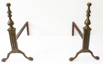 A pair of early 20th century brass fire dogs: each on two outset feet terminating in animal's paw