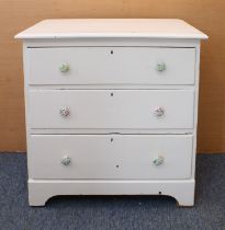 An early 20th century (later white painted) pine chest of three full graduated drawers, raised on