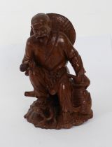 A Chinese carved boxwood figure of a seated fisherman - first half 20th century, with inset glass