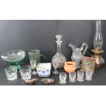 Various glassware to include an early 20th century oil lamp, a large decanter, a pedestal bowl, a