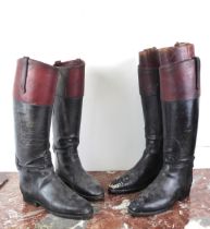 A pair of vintage black and dark tan leather riding boots with beech wood and brass boot trees -