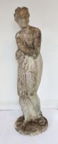 A large composite stone garden sculpture of a classical female figure - with attractive weathered