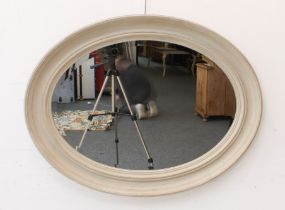 A 1920s painted oval mirror: with moulded frame and bevelled plate, 66.5 x 86.5cm.