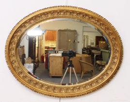 An oval  gilt and composition mirror in the 19th century style - modern, the moulded frame with