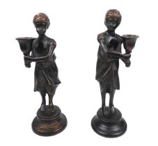 A pair of bronze candlesticks modelled as figurines (possibly Middle Eastern or North African