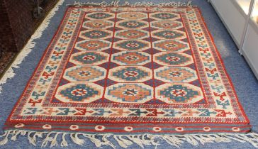 A Turkish Caucasian style rug - with three rows of seven octagonal medallions in pale buff, coral