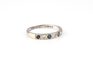 An 18ct white gold, sapphire and diamond half eternity ring - hallmarked London 1978, the four round