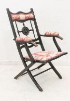 A Victorian upholstered, ebonised beech wood folding chair in the Aesthetic taste - the top rail,