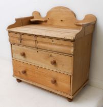 A Victorian pine washstand chest: the shaped three-quarter gallery with corner shelves, over two