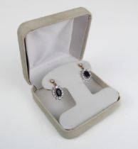 A pair of unmarked white and yellow metal gem-set earrings (boxed).