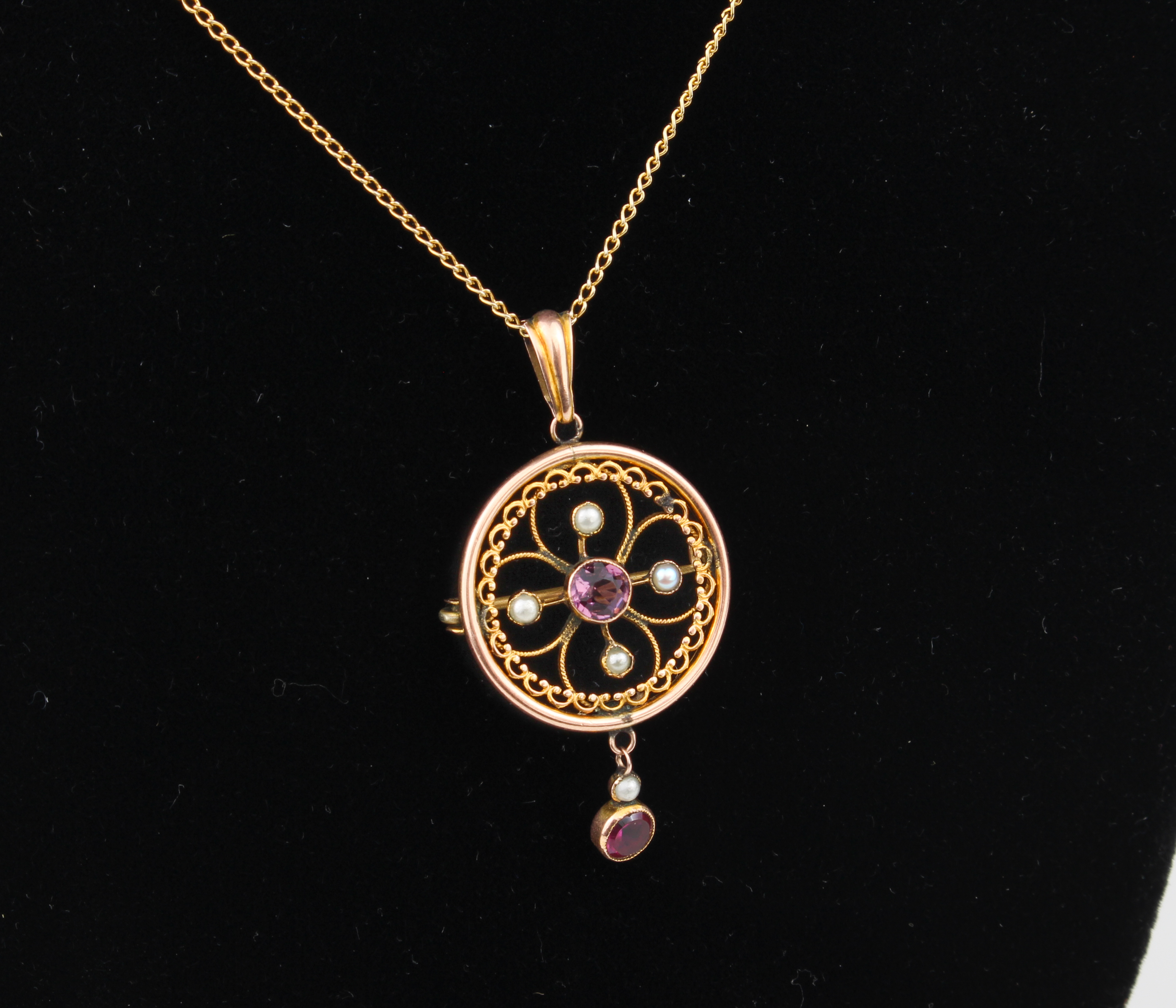 An early 20th century 9ct rose gold, amethyst and seed pearl pendant brooch - target shaped with a