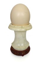 An ostrich egg and turned alabaster vase on Oriental hardwood stand. (2)