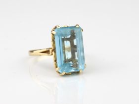 An 18ct yellow gold and aquamarine single stone ring - stamped '18CT', the emerald-cut aquamarine,