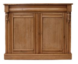 A Victorian waxed pine cupboard bookcase - the flared, moulded top over a pair of arched glazed