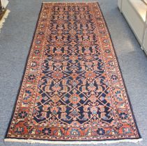 A Persian hand-knotted wool runner - the dark-blue field with joined diamond-shaped floral