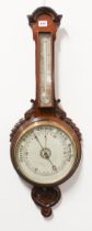 An Edwardian carved mahogany aneroid wheel barometer - the silvered dial signed for the retailer, '