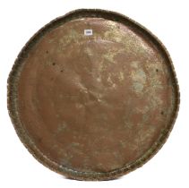 An antique Indian tinned copper tray - the circular tray chased with a central floral rosette and