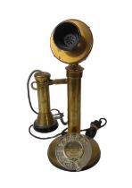 A vintage brass and black bakelite candlestick telephone - with plated brass dial, 31.5cm. high.