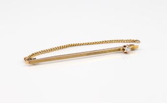 A 9ct gold bar brooch or tie pin - marked '9CT', the plain bar set with a single old cut diamond