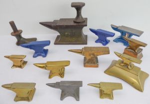 A series of miniature cast brass anvils, together with painted examples, and a miniature iron