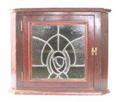 An early 20th century style (later) stained pine hanging corner cupboard with Art Nouveau style