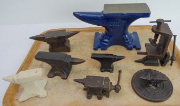 Six miniature anvils (five cast-iron and one stoneware example) and two miniature vices. The largest