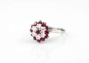 An 18ct platinum and white gold, ruby and diamond cluster ring - stamped 'PLAT' and '18CT', with a